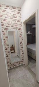 a brick wall with a mirror in a bedroom at Dois quartos mobiliado próximo a praia in Vila Velha +25 photos
