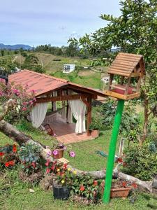 a wooden bird house on a pole in a garden at Finca Cercanías Marinilla - Casa Campestre in Marinilla