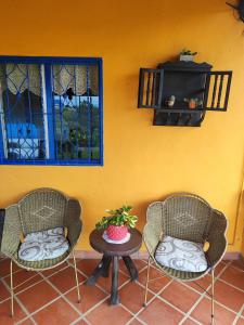 two chairs and a table in front of a wall at Finca Cercanías Marinilla - Casa Campestre in Marinilla