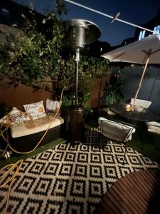 a lamp on a patio with a couch and an umbrella at Cluaine Meala cottage in Isleworth