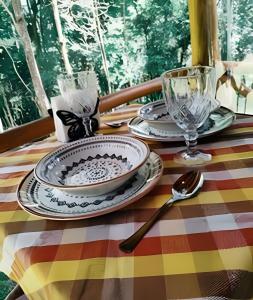 a table with plates and glasses on a colorful table cloth at Diamond Cabin in the Forest | Hot Tub | AC | Fire Pit in Gonçalves +14 photos