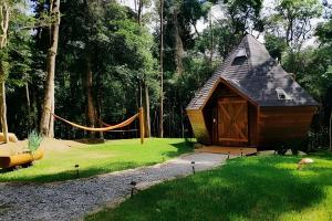 a small cabin in a yard with a hammock at Diamond Cabin in the Forest | Hot Tub | AC | Fire Pit in Gonçalves