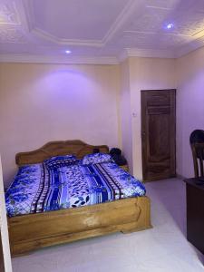 a bedroom with a bed with a blue blanket on it at CEO Da Gracia Hotel, Irewon, Ijebu Ode in Ijebu Ode
