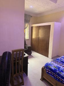 a bedroom with a bed and a desk and a chair at CEO Da Gracia Hotel, Irewon, Ijebu Ode in Ijebu Ode