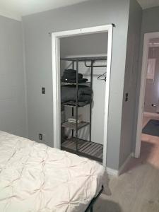 a bedroom with a closet with a bed and a mirror at Cosy single-level home with laundry and parking in Huntington