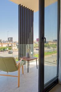 a room with a table and a chair and a window at VESTA - Maison Zayed City in Sheikh Zayed