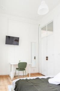 a bedroom with a green chair and a desk at Bica Palace - Residence in Center of Lisbon in Lisbon +48 photos