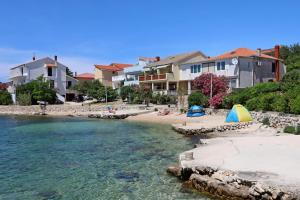 a group of houses and a beach next to the water at Apartment Mandre 4105a in Kolan