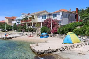 two tents on a beach next to a house at Apartment Mandre 4105a in Kolan +5 photos