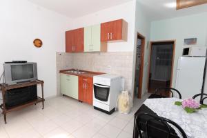 a kitchen with a stove and a microwave and a tv at Apartment Mandre 4105a in Kolan
