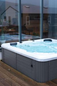 a jacuzzi tub in a room with a window at High end 3 BR Spacious Villa for 6 guests in Norðskáli