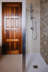 a bathroom with a shower and a wooden door at Appartamento Melo Grano in Tuoro sul Trasimeno +18 photos