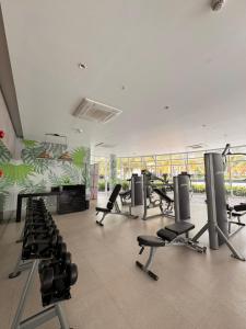 a gym with treadmills and chairs in a room at Cloud Haven Suite at Azure North Pampanga in San Fernando