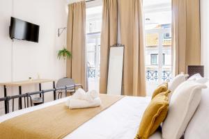 a bedroom with a bed and a large window at Bica Palace - Residence in Center of Lisbon in Lisbon