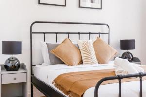a bedroom with a bed with pillows and two lamps at Bica Palace - Residence in Center of Lisbon in Lisbon
