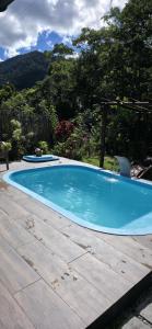 a large blue swimming pool in a yard at Casa da Lu in Macaé