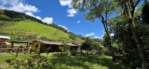 a house with a green hill in the background at Casa da Lu in Macaé