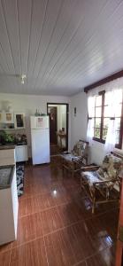 a kitchen with two chairs and a white refrigerator at Casa da Lu in Macaé