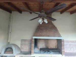a ceiling fan hanging from the side of a fireplace at Casa chalet cerca nodo y estadio in Santiago del Estero +3 photos