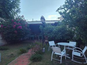 a patio with a table and chairs and flowers at Casa chalet cerca nodo y estadio in Santiago del Estero