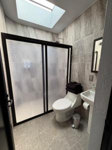 a bathroom with a toilet and a sink at Hotel Casa FRALO in Atotonilco el Alto