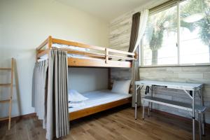 a bedroom with a bunk bed and a desk at Guest House Goofy in Hyuga