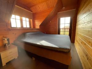 a bedroom with a bed in a wooden cabin at Forest Villa, Rural Twente in Den Ham