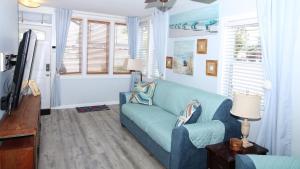 a living room with a blue couch and a tv at Shell Shack in Villas