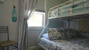 a bedroom with a bunk bed with a pillow and a window at Shell Shack in Villas
