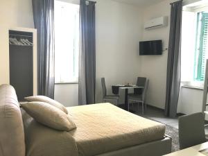 1 dormitorio con cama, mesa y ventana en Deluxe B&B Centrocitta, en Reggio Calabria