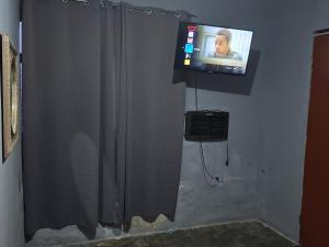a bathroom with a tv and a shower curtain at Mi casa in Ciudad Juárez