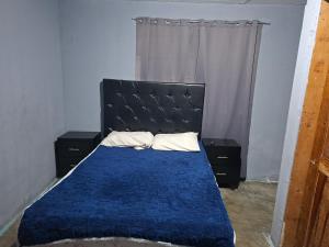 a bedroom with a bed with a blue comforter at Mi casa in Ciudad Juárez