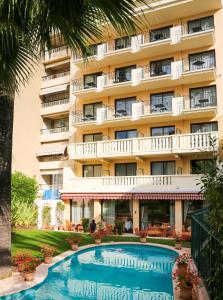 un hotel con piscina di fronte a un edificio di Sun Riviera Hotel a Cannes