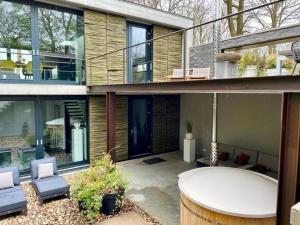 a house with a patio with a hot tub at Wellness Villa with Private Spa in Oosterhout