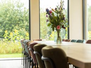 a vase of flowers sitting on a table with chairs at Villa with Heated Pool, Sauna in Aalten