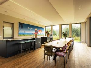 a large dining room with a long table and chairs at Villa with Heated Pool, Sauna in Aalten