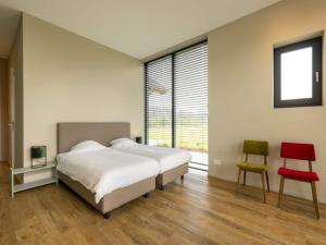a bedroom with a large bed and two chairs at Villa with Heated Pool, Sauna in Aalten +27 photos