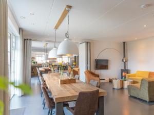 a dining room and living room with a table and chairs at Grand Villa with Sauna & Jacuzzi in Den Burg