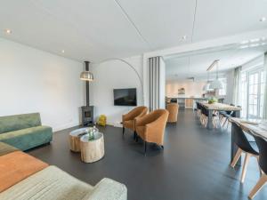a living room with a couch and chairs and a table at Grand Villa with Sauna & Jacuzzi in Den Burg
