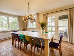 a dining room with a wooden table and chairs at Achterhoek Estate with Private Pool in Aalten