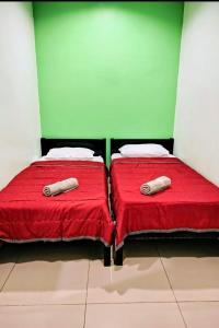 two beds sitting next to each other in a room at Feringghi Stay Iinn in Batu Ferringhi