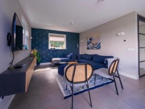 a living room with a blue couch and a table at Water Villa, Sauna & Beach in Sibculo