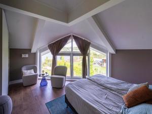 a bedroom with a bed and two chairs and a large window at Water Villa, Sauna & Beach in Sibculo +19 photos