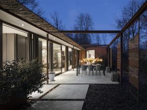 a patio with a table and chairs in a house at Wellness Villa with Private Sauna in Oosterhout