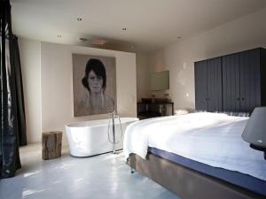 a bedroom with a large bed and a bath tub at Wellness Villa with Private Sauna in Oosterhout +34 photos