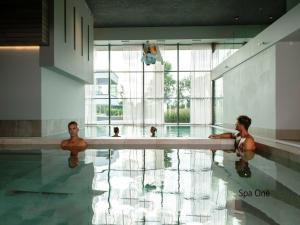 two men are in a swimming pool at Wellness Villa with Private Sauna in Oosterhout