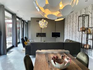 a living room with a couch and a table at Wellness Villa with Private Sauna in Oosterhout