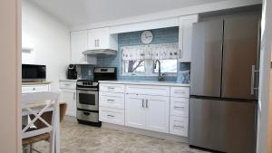 a kitchen with white cabinets and a stainless steel refrigerator at Summer Breeze in Cape May Point