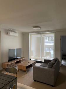a living room with a couch and a tv at Morgan Suites in Brisbane