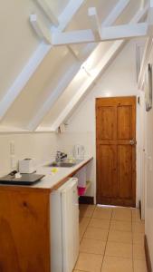 a kitchen with a sink and a wooden door at Paradise Cove Lodge in Arutanga